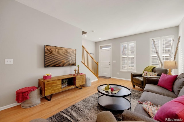 living room with light wood-type flooring, recessed lighting, baseboards, and stairs