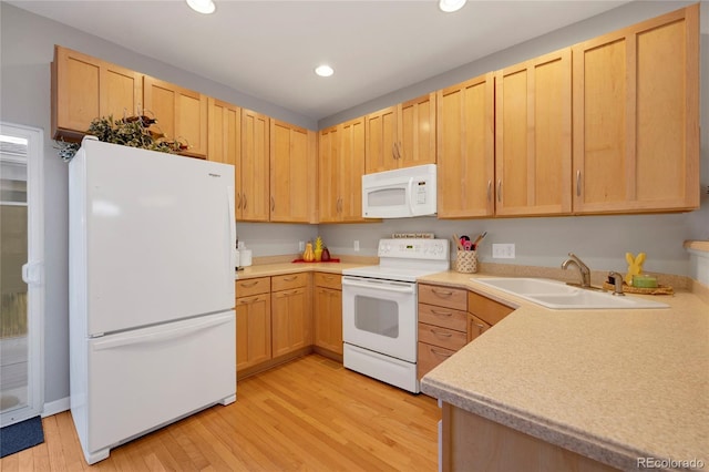 kitchen featuring recessed lighting, light wood-style flooring, light brown cabinetry, a sink, and white appliances