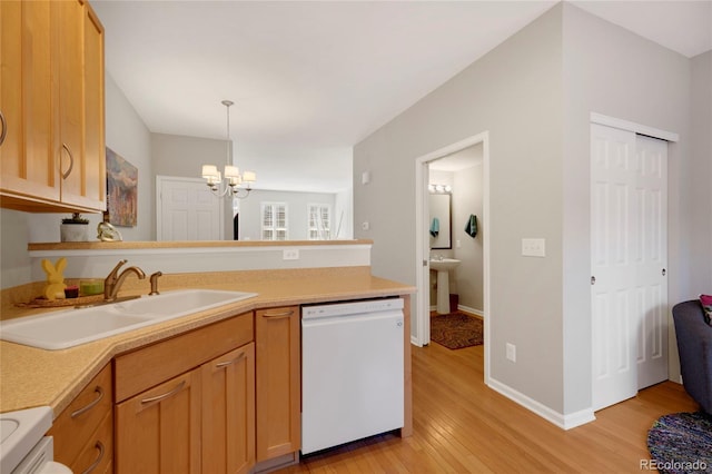 kitchen featuring light countertops, an inviting chandelier, white dishwasher, a sink, and light wood-type flooring