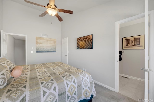 carpeted bedroom featuring visible vents, ceiling fan, baseboards, and tile patterned floors