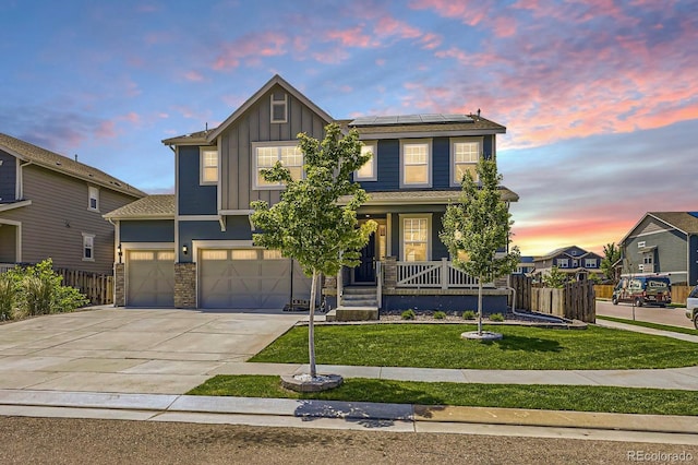 10991 Xanadu St, Commerce City, CO 80022 - view of front of house with board and batten siding, roof mounted solar panels, concrete driveway, a porch, and an attached garage