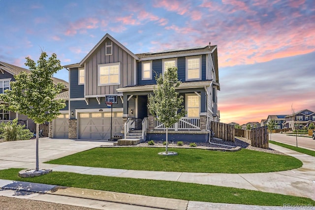 10991 Xanadu St, Commerce City, CO 80022 - view of front of home with stone siding, board and batten siding, concrete driveway, an attached garage, and covered porch