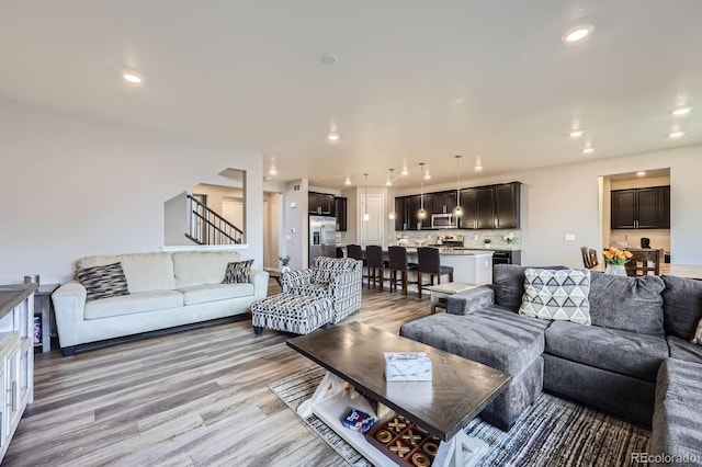 10991 Xanadu St, Commerce City, CO 80022 - living room with light wood finished floors, stairs, and recessed lighting