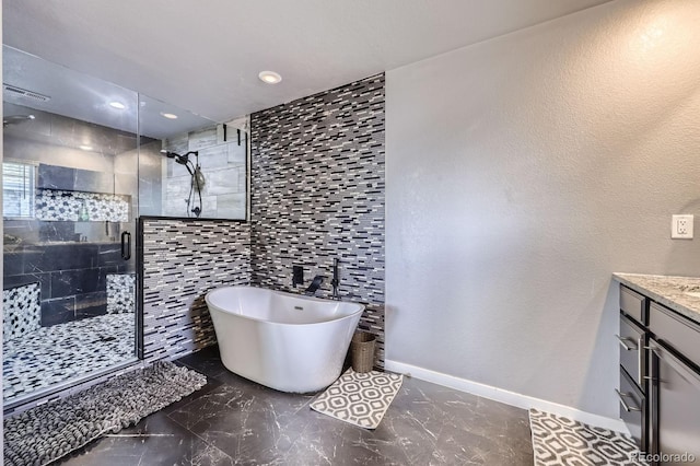 10991 Xanadu St, Commerce City, CO 80022 - full bathroom featuring vanity, a shower stall, a freestanding bath, recessed lighting, and marble finish floors