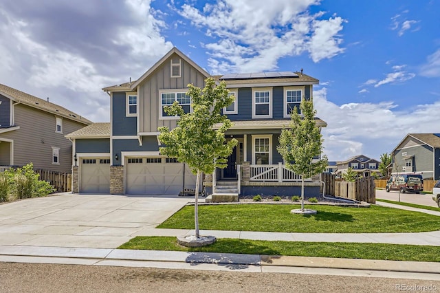 10991 Xanadu St, Commerce City, CO 80022 - view of front of house with board and batten siding, solar panels, a porch, driveway, and stone siding