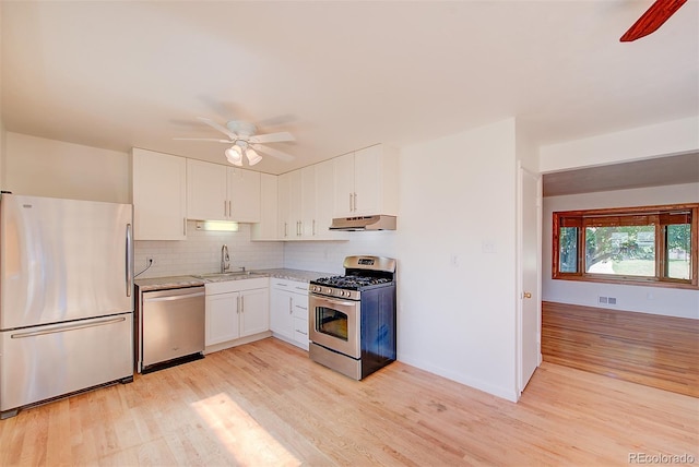 6054 Iris Way, Arvada, CO 80004 - kitchen with stainless steel appliances, a ceiling fan, under cabinet range hood, and light wood-style floors