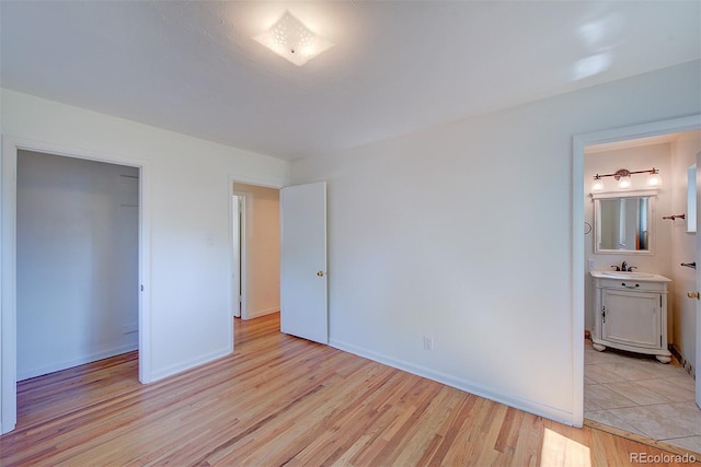 6054 Iris Way, Arvada, CO 80004 - unfurnished bedroom with light wood-style flooring and connected bathroom