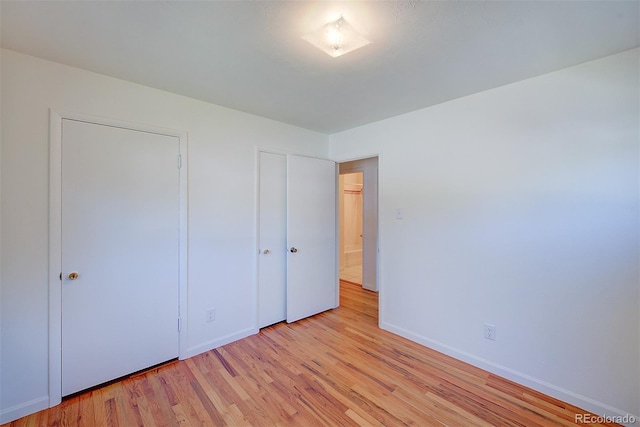 6054 Iris Way, Arvada, CO 80004 - unfurnished bedroom with baseboards and light wood-style floors