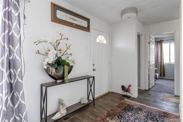 foyer entrance featuring dark hardwood / wood-style flooring and a textured ceiling