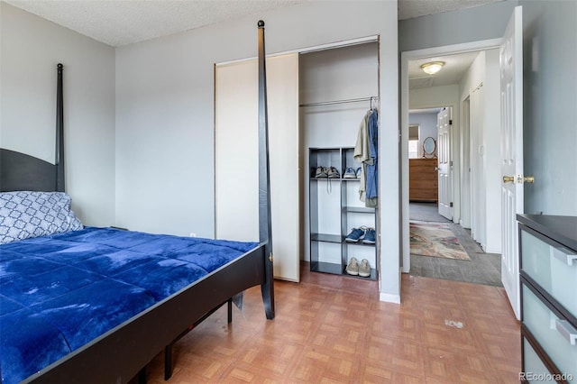 bedroom featuring parquet flooring, a closet, and a textured ceiling