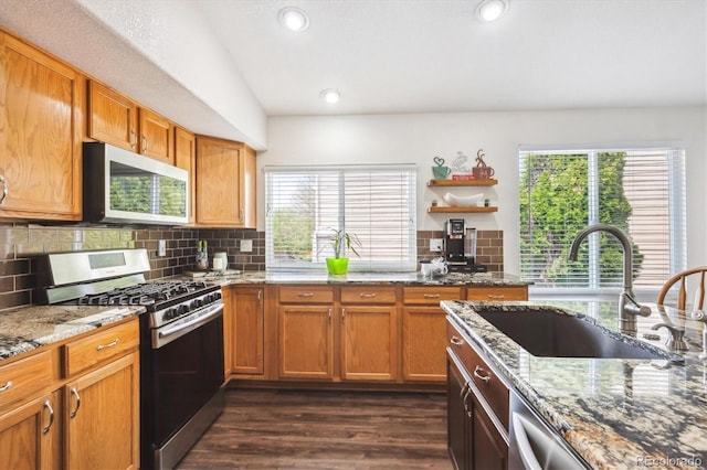 kitchen featuring plenty of natural light, a sink, decorative backsplash, and appliances with stainless steel finishes