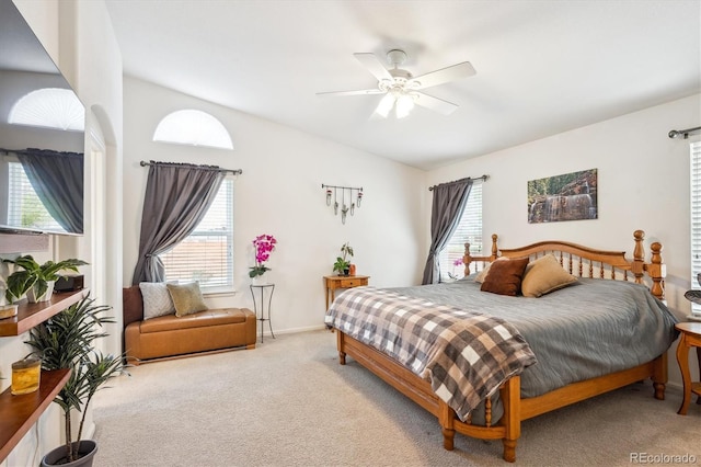 bedroom with a ceiling fan, lofted ceiling, light carpet, and multiple windows