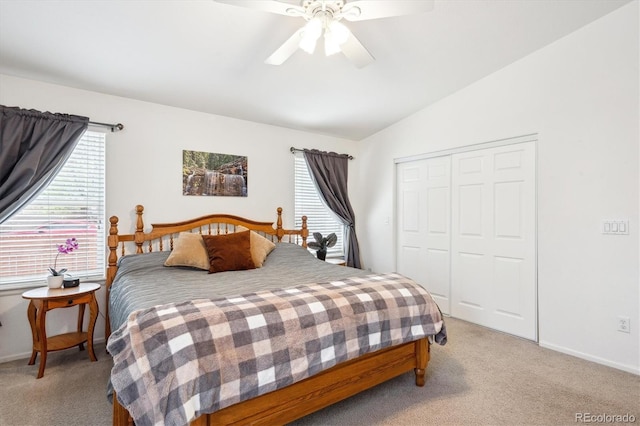 bedroom featuring a closet, a ceiling fan, light carpet, and vaulted ceiling