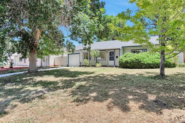3052 S Grape Way, Denver, CO 80222 - view of front facade featuring a garage, a shingled roof, and a front lawn