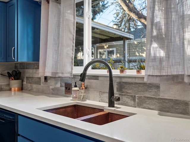 kitchen featuring tasteful backsplash, dishwasher, blue cabinetry, and sink