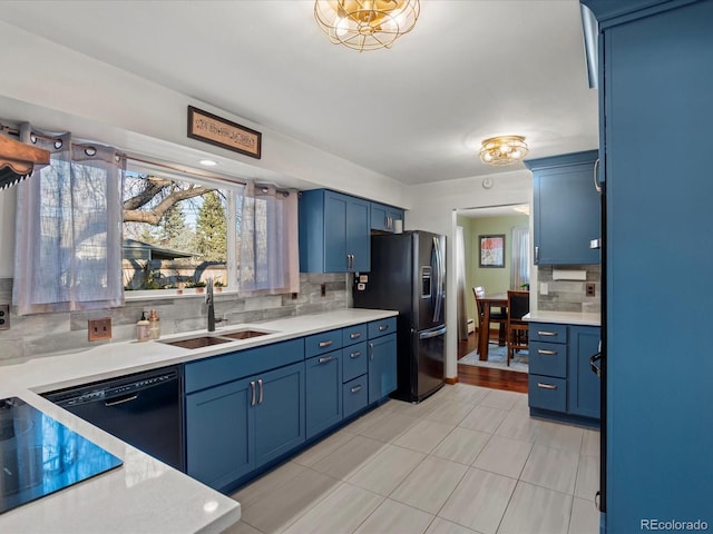 kitchen with sink, blue cabinets, black appliances, and backsplash