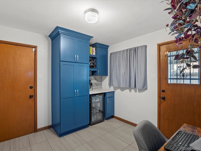 kitchen with blue cabinetry, backsplash, and wine cooler