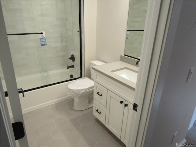 bathroom with shower / bath combination with glass door, tile patterned flooring, vanity, and toilet