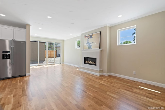1970 S Logan St, Denver, CO 80210 - unfurnished living room with light wood-type flooring, a glass covered fireplace, baseboards, ornamental molding, and recessed lighting