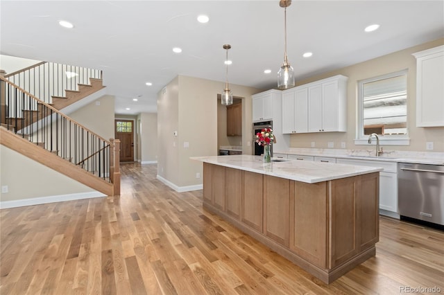 1970 S Logan St, Denver, CO 80210 - kitchen with appliances with stainless steel finishes, a sink, white cabinetry, a kitchen island, and light wood-style floors