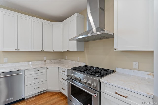 1970 S Logan St, Denver, CO 80210 - kitchen featuring stainless steel appliances, wall chimney exhaust hood, and white cabinets