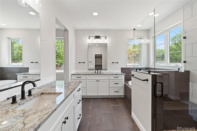 1970 S Logan St, Denver, CO 80210 - bathroom featuring recessed lighting, a tub, tile patterned floors, and two vanities