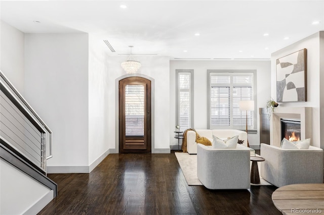 entryway with plenty of natural light, dark hardwood / wood-style floors, and an inviting chandelier