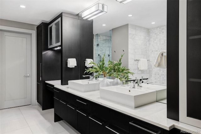 bathroom with tile patterned flooring, vanity, tile walls, and a shower