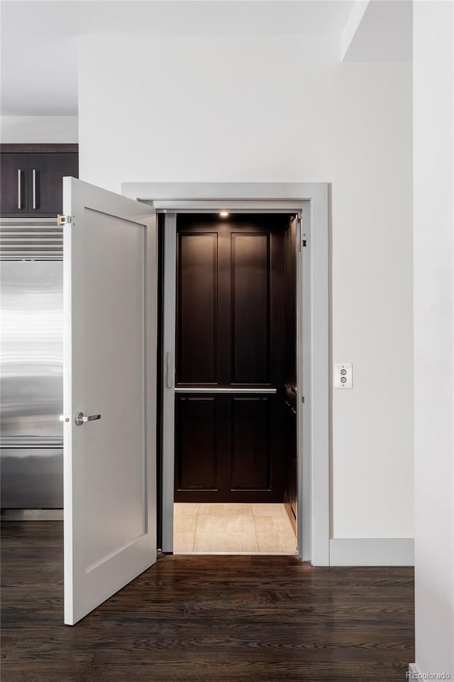 corridor with hardwood / wood-style flooring