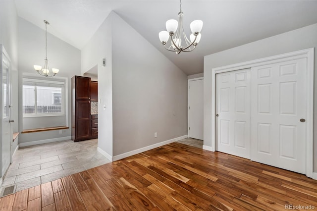13849 W 66th Dr, Arvada, CO 80004 - unfurnished bedroom featuring a chandelier, wood finished floors, a closet, and high vaulted ceiling