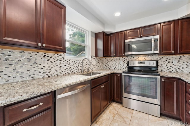 13849 W 66th Dr, Arvada, CO 80004 - kitchen with appliances with stainless steel finishes, decorative backsplash, light stone countertops, light tile patterned floors, and dark brown cabinetry