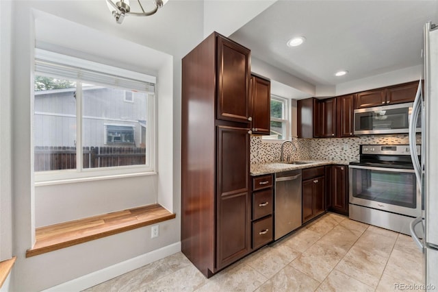 13849 W 66th Dr, Arvada, CO 80004 - kitchen with appliances with stainless steel finishes, decorative backsplash, dark brown cabinetry, recessed lighting, and light stone countertops