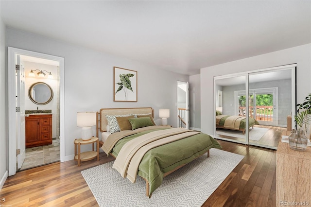 13849 W 66th Dr, Arvada, CO 80004 - bedroom featuring access to outside, wood finished floors, and ensuite bath