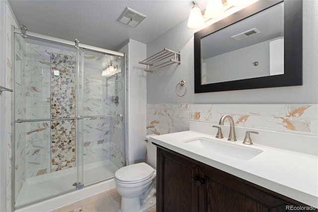 13849 W 66th Dr, Arvada, CO 80004 - bathroom with a marble finish shower, vanity, tile patterned floors, and tile walls