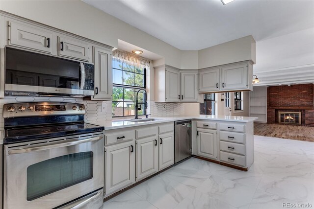 10851 E Iliff Pl, Aurora, CO 80014 - kitchen with appliances with stainless steel finishes, light countertops, light marble finish flooring, a peninsula, and tasteful backsplash