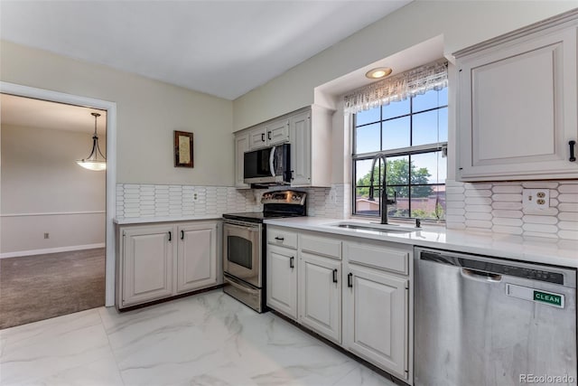 10851 E Iliff Pl, Aurora, CO 80014 - kitchen with stainless steel appliances, light countertops, light marble finish floors, decorative backsplash, and hanging light fixtures