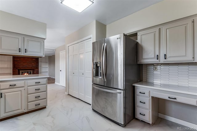 10851 E Iliff Pl, Aurora, CO 80014 - kitchen featuring stainless steel refrigerator with ice dispenser, light countertops, backsplash, and light marble finish floors