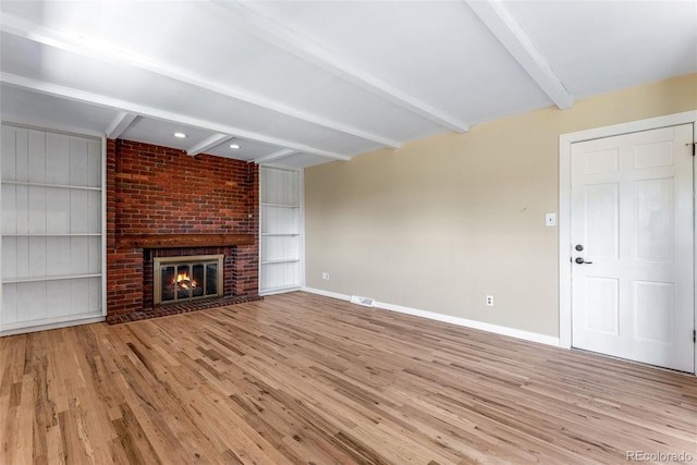 10851 E Iliff Pl, Aurora, CO 80014 - unfurnished living room with beam ceiling, wood finished floors, a fireplace, and built in features