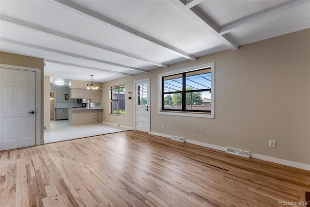10851 E Iliff Pl, Aurora, CO 80014 - unfurnished living room featuring a chandelier, light wood finished floors, and beam ceiling