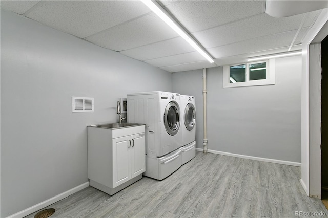 5280 S Logan St, Littleton, CO 80121 - laundry room with separate washer and dryer, light wood finished floors, and cabinet space