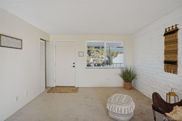 foyer with light carpet and a textured ceiling