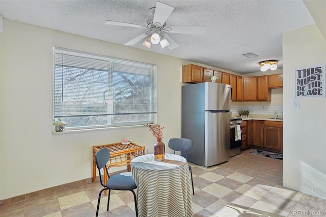 kitchen with tasteful backsplash, ceiling fan, a textured ceiling, and appliances with stainless steel finishes