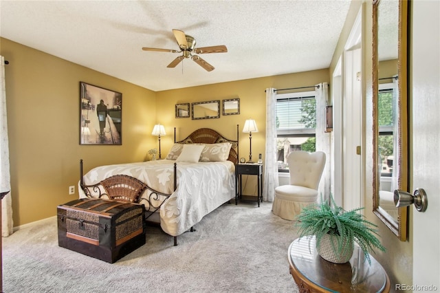 carpeted bedroom with ceiling fan and a textured ceiling