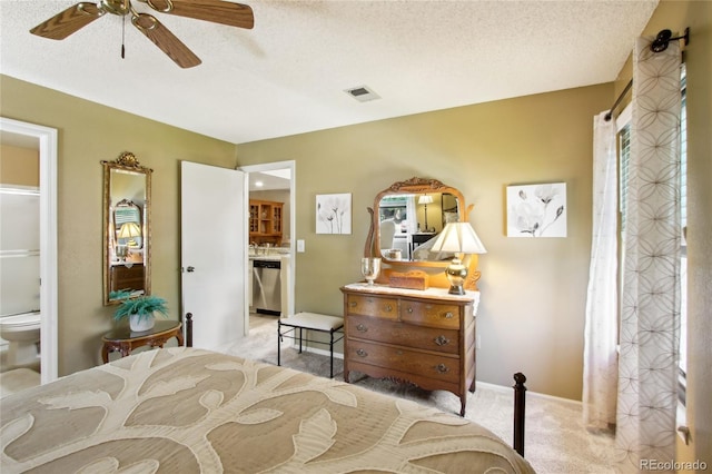 carpeted bedroom with a textured ceiling, ceiling fan, and ensuite bath