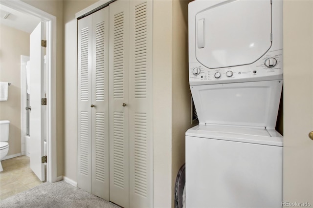 laundry room with stacked washing machine and dryer and baseboards
