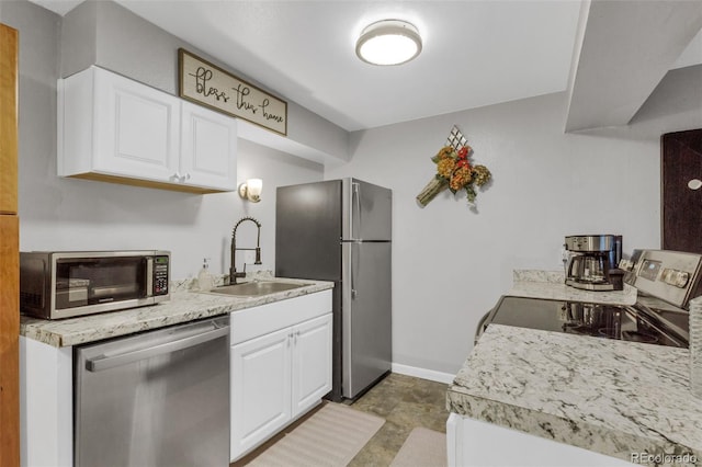 1611 Garfield Ave Unit 2, Louisville, CO 80027 - kitchen featuring appliances with stainless steel finishes, a sink, white cabinets, light countertops, and baseboards