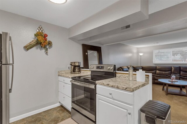 1611 Garfield Ave Unit 2, Louisville, CO 80027 - kitchen featuring appliances with stainless steel finishes, a peninsula, white cabinets, open floor plan, and baseboards
