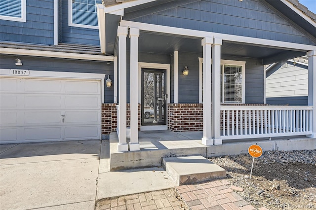 view of exterior entry featuring brick siding and covered porch