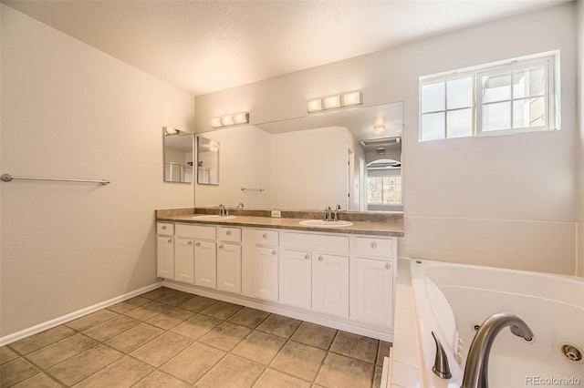 bathroom with a sink, baseboards, a tub with jets, and double vanity