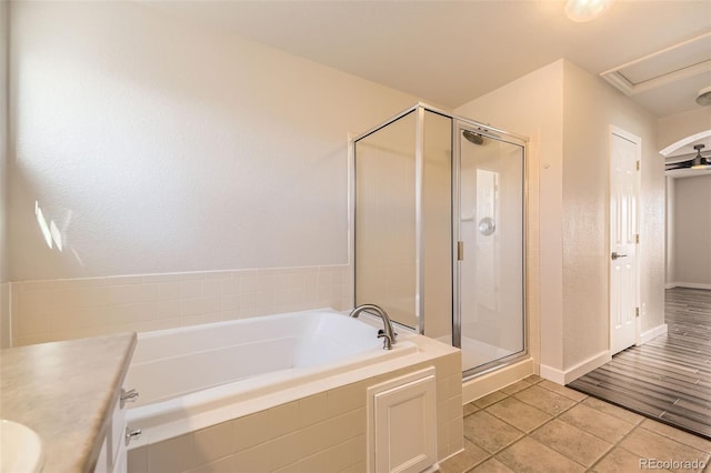 bathroom featuring a shower stall, baseboards, a garden tub, tile patterned floors, and vanity